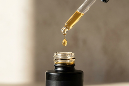 Macro shot of a PRE-LIGHT Copper Peptide Serum dropper releasing a drop
