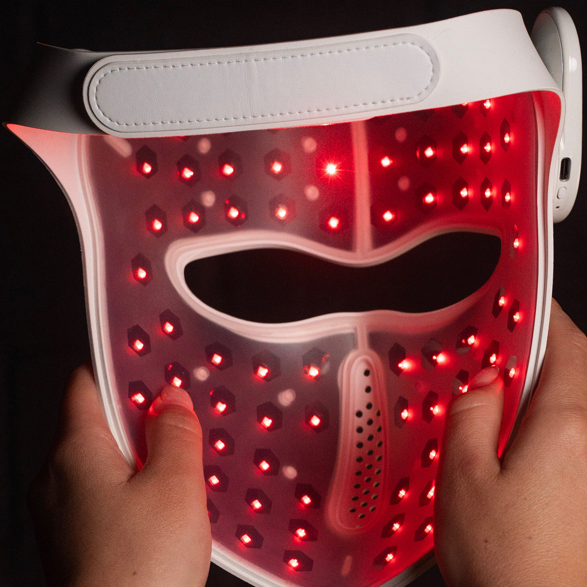 Back of the Luxen Veil — interior laser diode array glowing red through the silicone shell