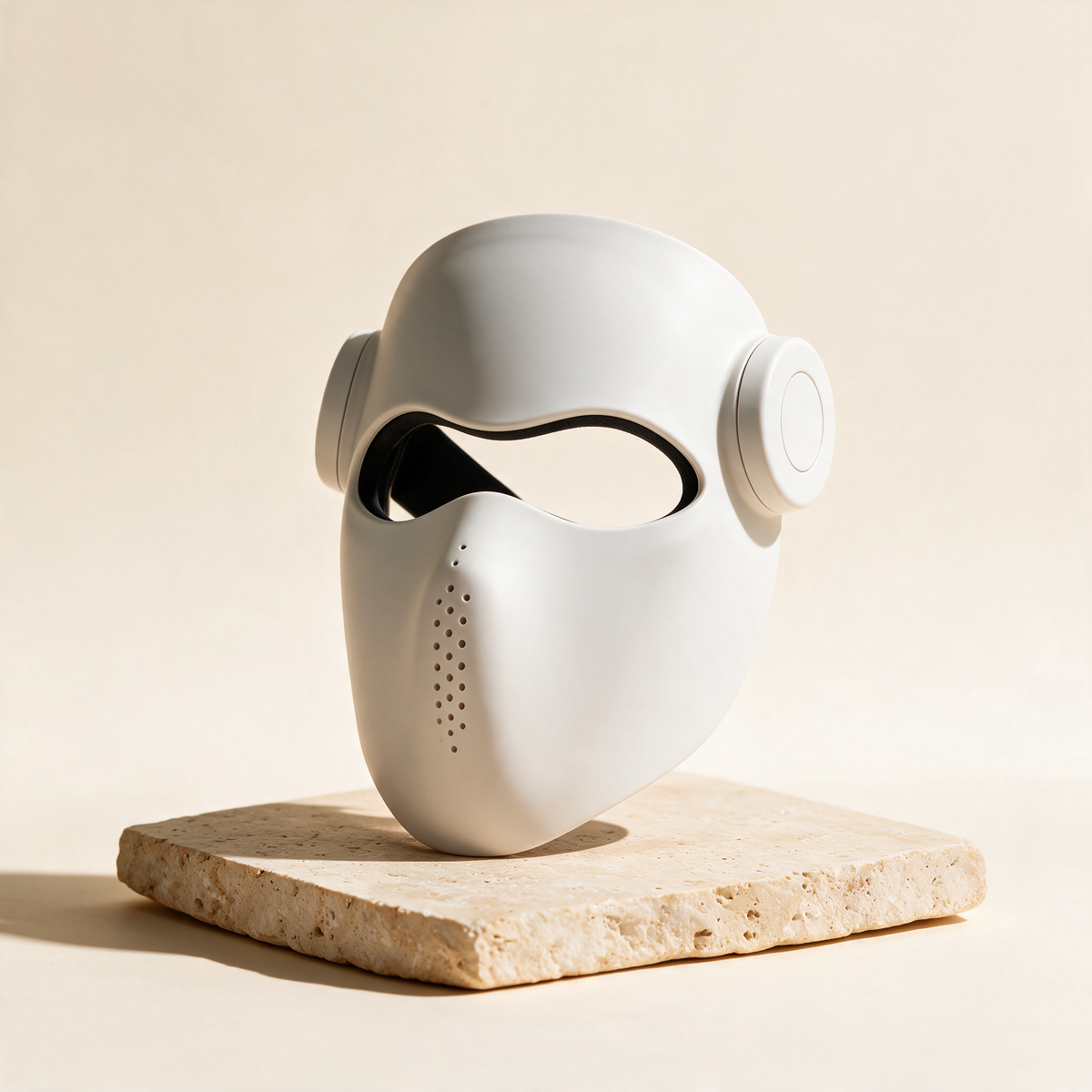 Luxen Veil laser mask in white on travertine stone — premium studio packshot