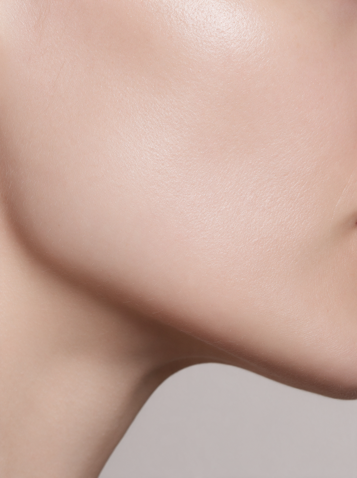 Close-up of skin along the jawline in soft studio light